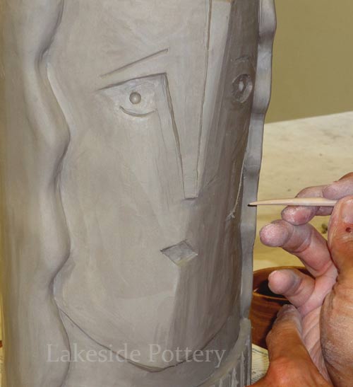 sculpting obstract face on vase