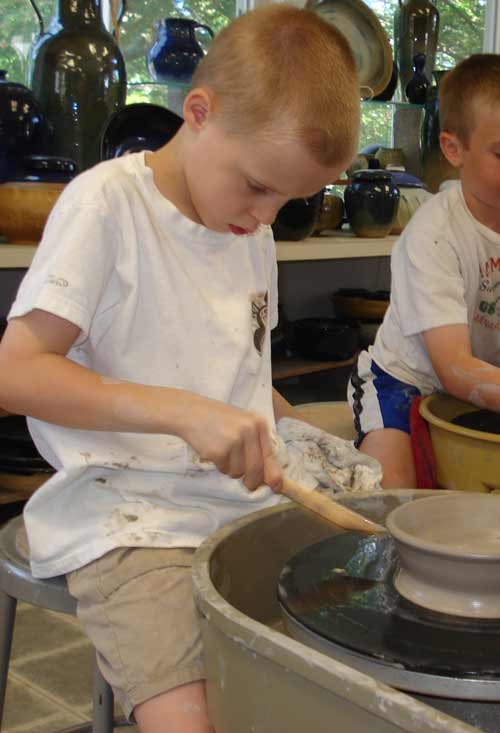 teaching children the pottery whee