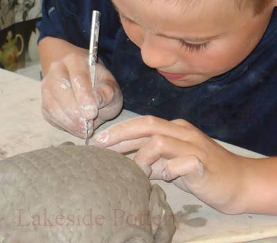 Boy making clay turtle