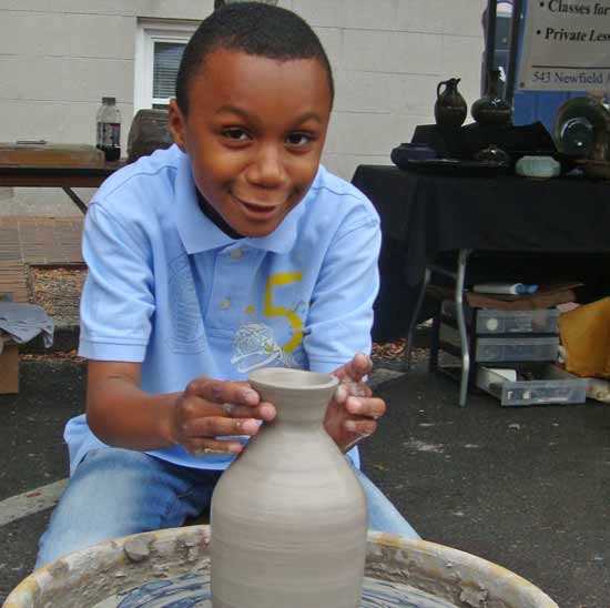 Tri-state area Art and Craft fair with children and adults trying pottery