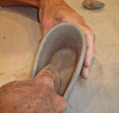 smooth all surfaces of the clay with a sponge, soft rib or finger