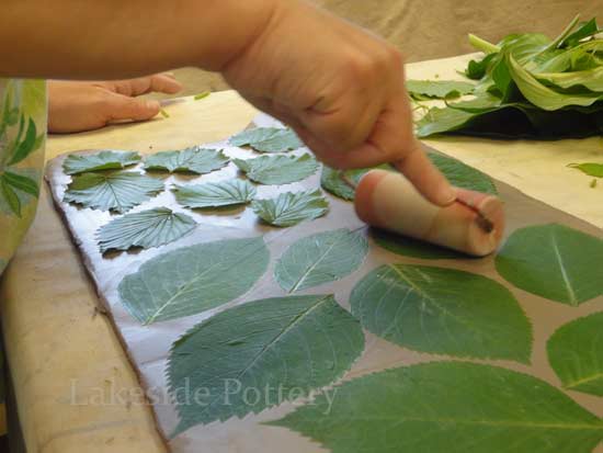 impressing leaves on clay
